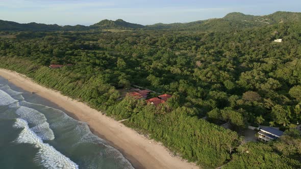 Long video of aerial orbit around beach front resort at Ventanas beach in Costa Rica. Drone circling