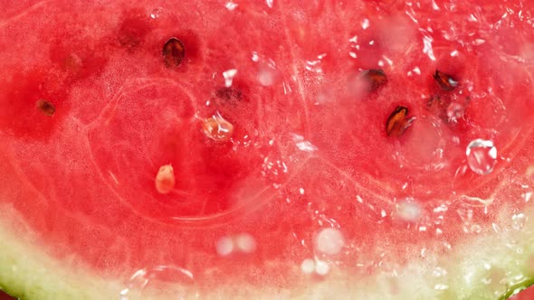 Super Slow Motion Macro Shot of Falling and Splashing Water Drops on Fresh Watermelon at 1000Fps