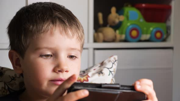 Kid Playing Mobile Game on Smartphone