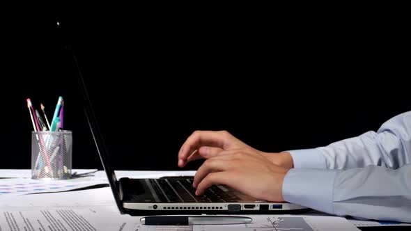 Businessman Working with His Laptop on Black Background