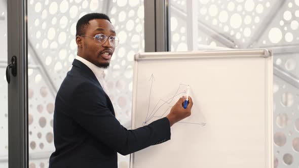 African American Architec Engineer Drawing Plan on Flip Chart at Office