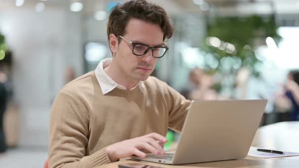 Young Male Designer Working on Laptop in Office