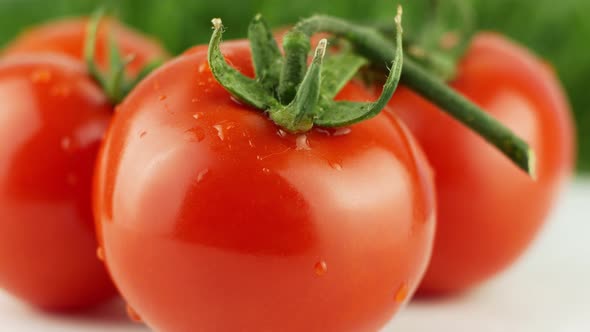 Ripe natural tomatoes close-up. Organic tomato rotating on a green background Macro shot.