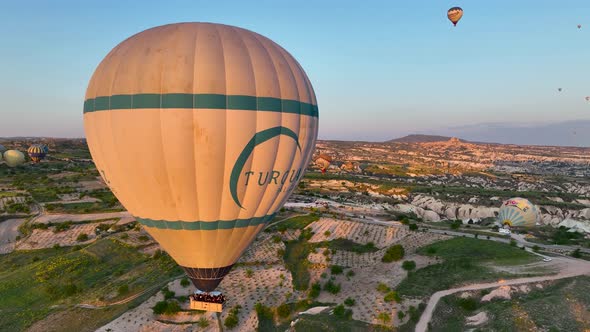 4K Aerial view of Goreme. Colorful hot air balloons fly over the valleys.