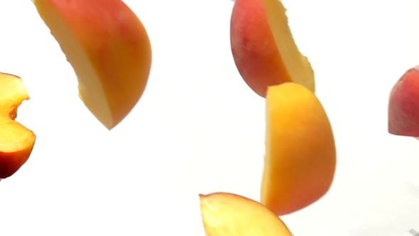 Peach Slices Fly Close-up on a White Background