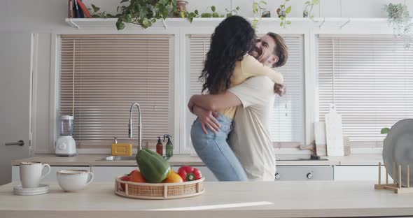 Heterosexual Multiethnic Couple Embracing in an Apartment 