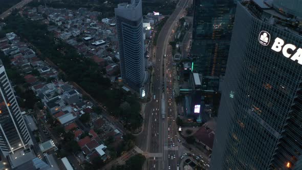 Aerial Tilting View Following Busy Multi Lane Traffic Into the Modern City with Tall Skyscrapers in
