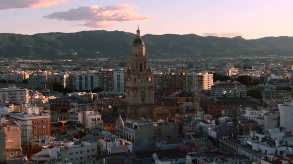 Close up aerial shot of Murcia Cathedral in Spain. Mountain cityscape view