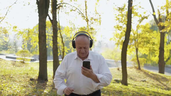 Man Waving Hand and Having Fun in Park While Listening to the Music and Chatting