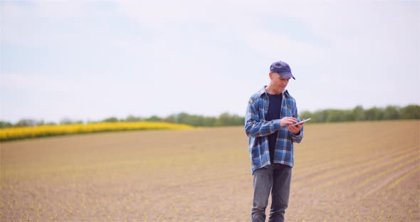 Agriculture, Food Production - Farmer Examining Crops at Field