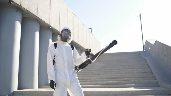 Cleaner with Pressurized Sprayer in Hands Going To Disinfect Public Places