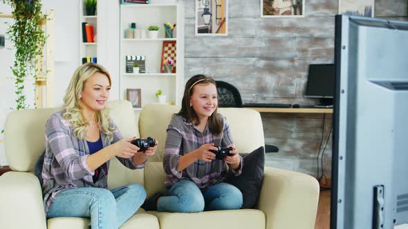 Beautiful Young Mother Playing Video Games with Her Daughter