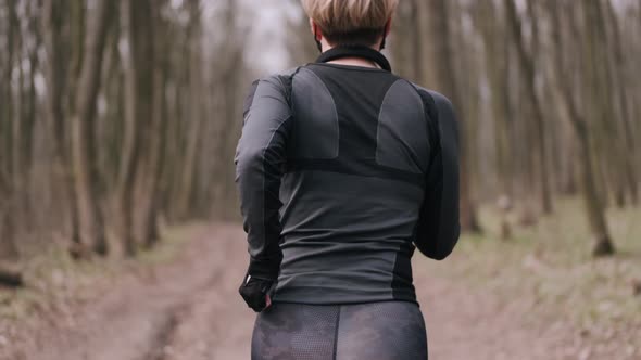 A Middle-aged Woman in a Mask Is Doing Morning Exercise Outside