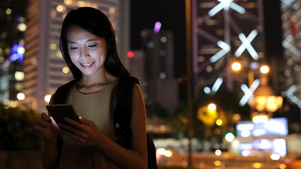 Woman use of smart phone in city at night 