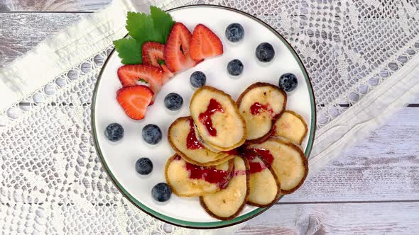 Pancakes with Strawberries Blueberries Pouring with Jam Rotate Slowly on Turntable