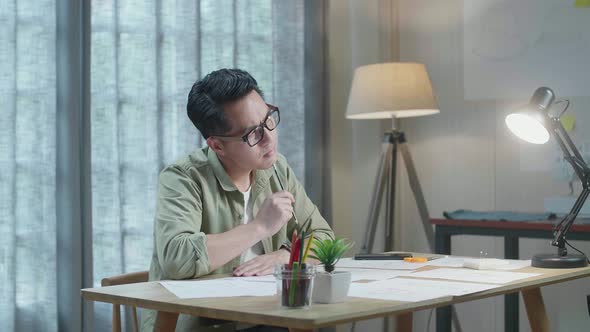 Asian Man Designer Thinking While Drawing On The Layout Bond At The Office
