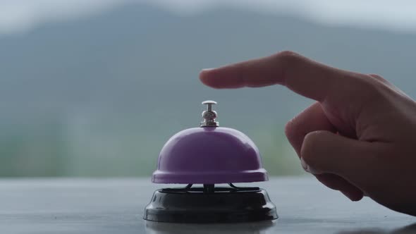 A Close Up of Nervous Young Woman Hand Strikes the Metal Service Bell on Hotel Reception