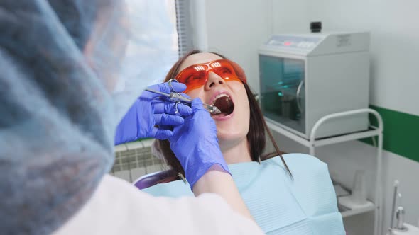 Dentist Is Making Anesthesia Stab To Scared Young Woman in Chair