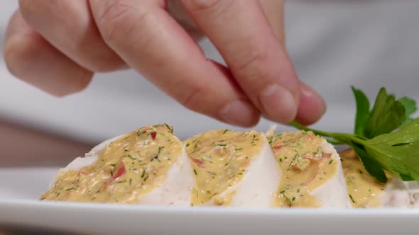 Woman Puts Parsley on Chicken Roll