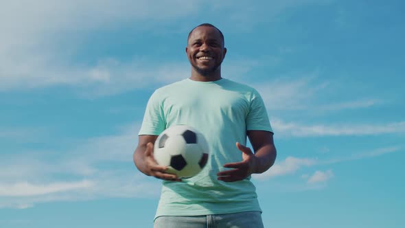 Cheerful Football Player Holding Ball Outdoors