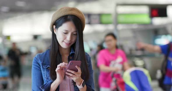 Woman search on mobile phone in the station