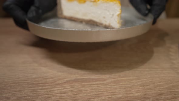 Female Hands Put Plate with Cheesecake with Jam on Table