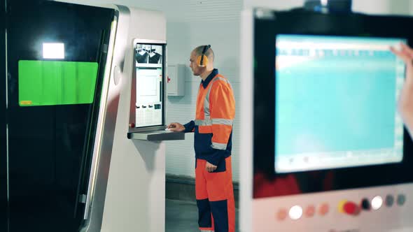 Factory Worker Is Operating Industrial Machine Through Display