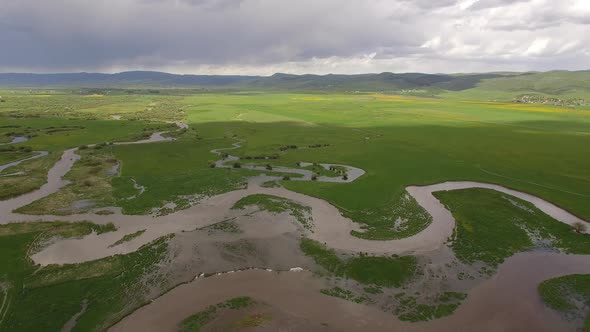 Aerial view of winding river flooding over the banks