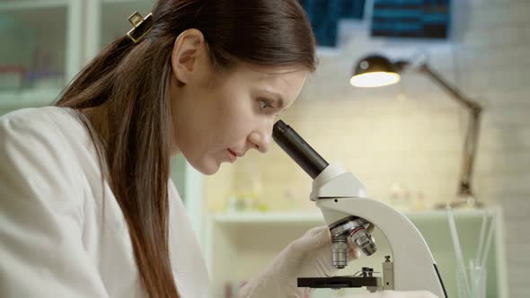 Female Doctor In Laboratory With Microscope