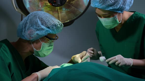 Low Angle Shot of Professional surgeons team performing surgery in operating room, surgeon, Assistan