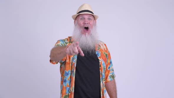 Happy Mature Bearded Tourist Man Smiling and Laughing While Pointing To Camera