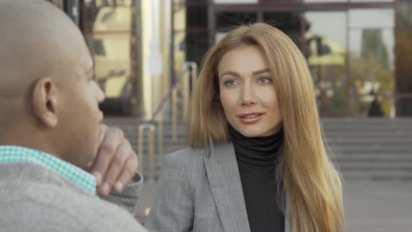 Attractive Young Businesswoman Talking To Her Colleague Outdoors