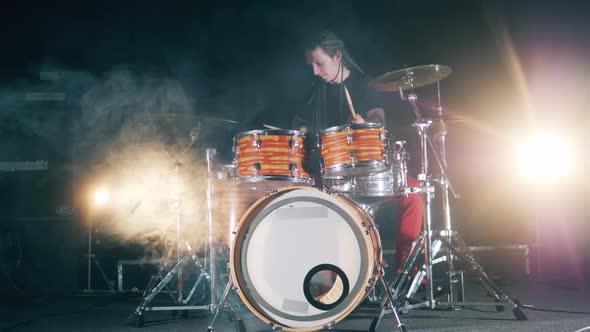 Male Drummer with Dreadlocks Is Playing the Drum Set. Male Drummer Playing Drums in Smoke.