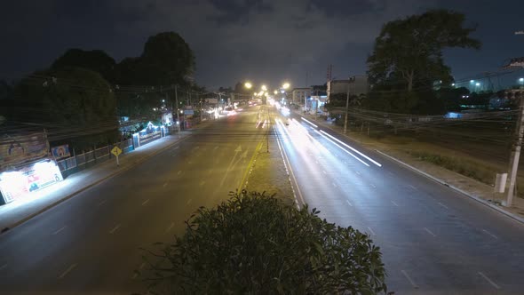 Static nightlapse of a busy highway and car trails at night from a high angle over the street.