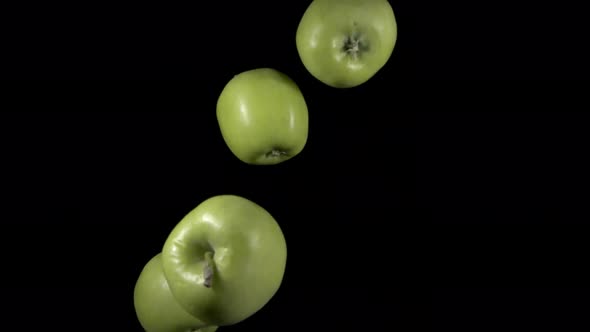 Flying Green Apples on a Black Background