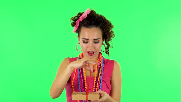 Girl Opens the Gift, Very Surprised and Rejoices. Green Screen