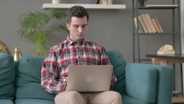 Man Working on Laptop on Sofa