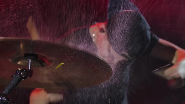 Young Rock Musician Plays Drumset in Dark Studio Among the Raindrops