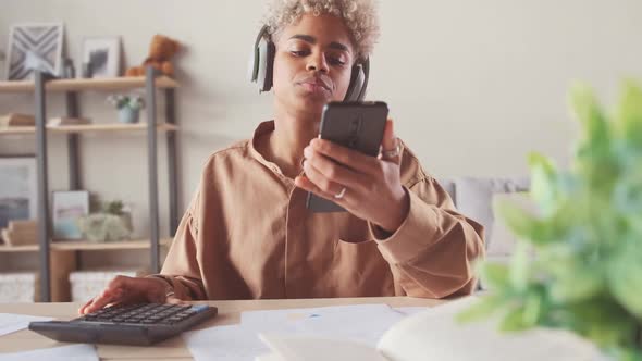 Afro Woman in Headphones Making Payment Online in Phone Ebanking App