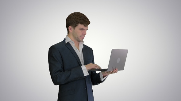 Businessman using laptop computer standing Great news on