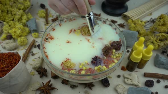 Woman's hand mixes natural ingredients in a glassware
