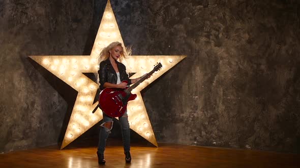 Sexy Girl with Electric Guitar in Leather, Shining Star in the Background, Slow Motion