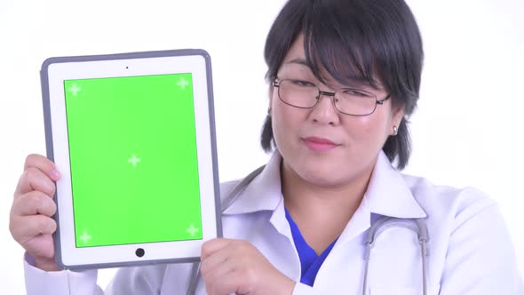 Face of Happy Overweight Asian Woman Doctor Showing Digital Tablet