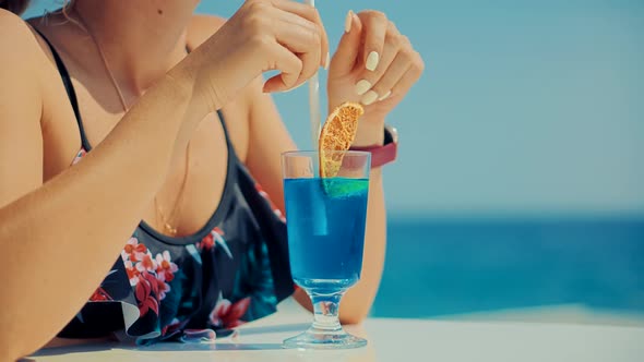 Woman Drinking Alcohol Blue Curacao Cocktail In Bar. Summer Holiday Vacation Travel On Sea Beach