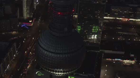 AERIAL: Close Up of Berlin Germany TV Tower Alexanderplatz at Night with City Lights Traffic 