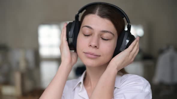 Young woman enjoying music in the headboards in the morning at home