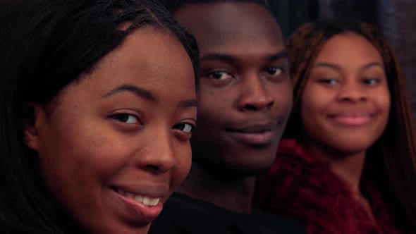 Three African Friends Together Smile To Camera in Living Room Detail of Faces