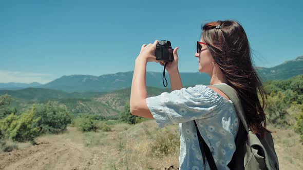 Young Traveler Woman Taking Photo of Amazing Landscape Using Camera Outdoor