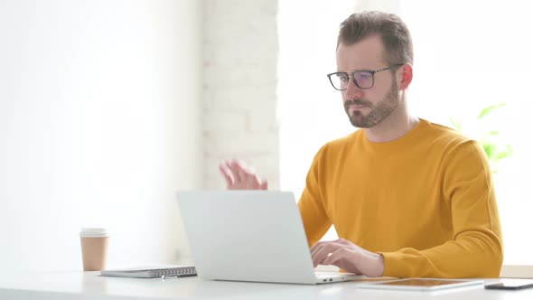 Man Talking on Video Call on Laptop in Office