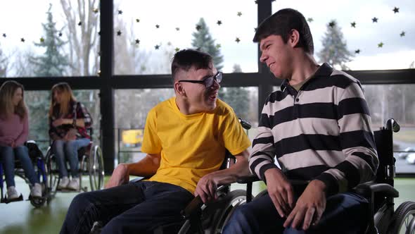 Cheerful Disabled Teenage Boys Chatting Indoors